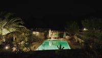 a swimming pool in a yard at night at une petite maison entre vignes et mer in Saint-Côme