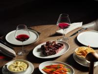 汤斯维尔Ardo的餐桌,带食物盘和两杯葡萄酒