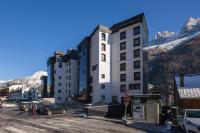 a tall white building with mountains in the background at Outa B 513 - Happy Rentals in Chamonix