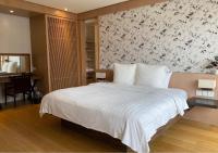 a bedroom with a white bed with a floral wallpaper at Beitou Sweet Me Hot Spring Resort in Taipei
