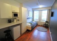 a small room with a bed and a living room at Forenom Aparthotel Lahti in Lahti