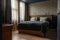 a bedroom with a bed with a wooden headboard at Gibsons Hotell in Jonsered