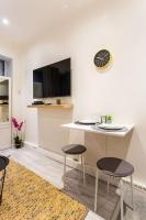 a kitchen with a table and two chairs and a clock at Condamine&#47;Batignolles : Cosy Studio in Paris
