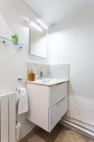 a white bathroom with a sink and a mirror at Condamine&#47;Batignolles : Cosy Studio in Paris