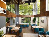 um restaurante com mesas e cadeiras e grandes janelas em Scenic, Munnar - IHCL SeleQtions em Munnar