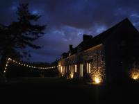 a building with lights on the side of it at night at L&#39;Echappée d&#39;Aristide - proche Giverny &amp; 50 min Paris in Houlbec-Cocherel