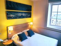 a hotel room with a bed and a window at Hôtel de la Gare - Restaurant Bistro Quai in La Roche-sur-Yon