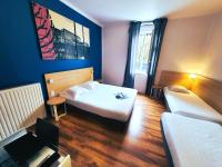 a hotel room with two beds and a table and a desk at Hôtel de la Gare - Restaurant Bistro Quai in La Roche-sur-Yon