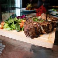 een stuk biefstuk op een snijplank met een salade bij St Isidro Suites Corporate Housing SPA & Wellness Center in Mexico-Stad