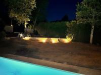 un chien assis dans une cour la nuit avec des lumières dans l&#39;établissement Grande maison familiale -12 pers, à Méré