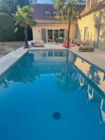 - une piscine d&#39;eau bleue en face d&#39;une maison dans l&#39;établissement Grande maison familiale -12 pers, à Méré