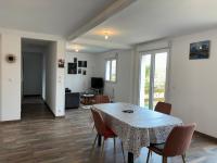 a dining room with a table and chairs and a living room at Les clés de jonzac-conciergerie la maison des 4 Saisons in Ozillac