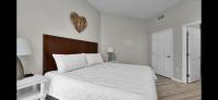 ein Schlafzimmer mit einem weißen Bett mit einem hölzernen Kopfteil in der Unterkunft The Palms of Destin-2116 in Destin