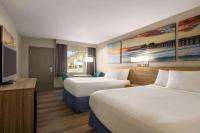 Ein Bett oder Betten in einem Zimmer der Unterkunft Days Inn by Wyndham Cocoa Beach Port Canaveral