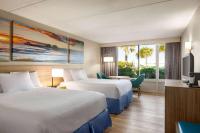 ein Hotelzimmer mit zwei Betten und einem Fernseher in der Unterkunft Days Inn by Wyndham Cocoa Beach Port Canaveral in Cocoa Beach