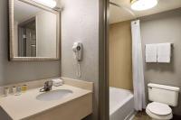 ein Badezimmer mit Waschbecken, Toilette und Spiegel in der Unterkunft Days Inn by Wyndham Cocoa Beach Port Canaveral in Cocoa Beach