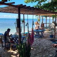 um grupo de pessoas sentadas em mesas na praia em Beija Flor em Gamboa