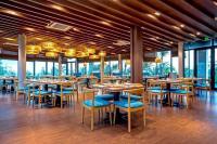 Un comedor con mesas y sillas y ventanas. en Khách Sạn - Resort Oceanami - Long Hải, en Long Hai