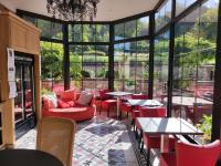 a restaurant with red chairs and tables and windows at Domaine du Clos Fleuri - Spa in Honfleur