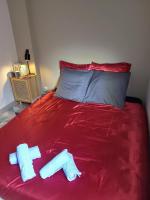 a red bed with two towels on top of it at Chambre d&#39;Hôtes calme et cosy, à 3min de la gare, centre ville, avec un lit de 160cm in Nevers