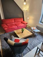 a living room with a red couch and a coffee table at Chambre d&#39;Hôtes calme et cosy, à 3min de la gare, centre ville, avec un lit de 160cm in Nevers