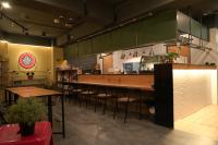 a restaurant with tables and chairs in a kitchen at Meeting Mates Hostel in Taipei