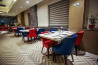 a dining room with tables and blue chairs at Ramada Plaza by Wyndham Lucknow in Lucknow