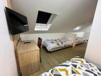 a small room with two beds and a flat screen tv at Hôtel NOROTEL in Brumath