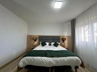 a bedroom with a large bed with a green blanket at Hôtel NOROTEL in Brumath