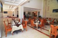a restaurant with tables and chairs in a room at Golden Beach Appart'hotel in Agadir