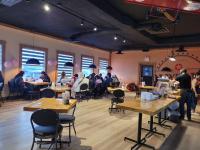 een groep mensen die aan een tafel in een kamer zitten bij Riverside Inn in Wabasca