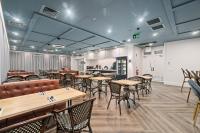 een eetkamer met houten tafels en stoelen bij Mercure Pakenham in Pakenham