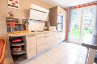 a kitchen with white cabinets and a large window at Le Sapin Parasol - Maison pour 7 pers. in Lussault-sur-Loire