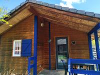 a log cabin with blue doors and a porch at Family&#39;s Camping Le Savoy in Challes-les-Eaux