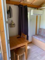 a small room with a wooden table and a bed at Family&#39;s Camping Le Savoy in Challes-les-Eaux