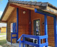 a tiny house with a blue bench in front of it at Family&#39;s Camping Le Savoy in Challes-les-Eaux