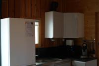 a kitchen with white cabinets and a white refrigerator at Family&#39;s Camping Le Savoy in Challes-les-Eaux