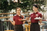 duas mulheres segurando pratos de comida nas mãos em Optima Rivne em Rivne