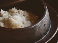 Una olla de metal llena de arroz sobre una mesa en Etajimasou Hotel & SPA Hiroshima, en Etajima