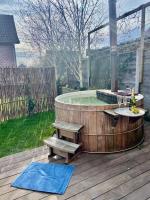 a hot tub with a table and benches on a deck at Fermette cosy, Bain nordique &amp; Baby foot in Fromelles