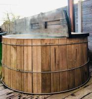 a large wooden hot tub with a grill in a yard at Fermette cosy, Bain nordique &amp; Baby foot in Fromelles
