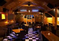 a restaurant with wooden tables and chairs and a checkered floor at Kings Ohakune in Ohakune