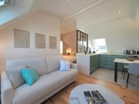 a living room with a white couch and a kitchen at Luxury flat with amazing view on Eiffel Tower in Paris