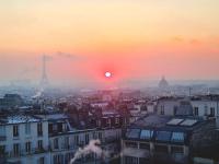 a view of a city with the sunset in the background at Luxury flat with amazing view on Eiffel Tower in Paris