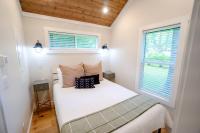 1 Schlafzimmer mit einem weißen Bett und 2 Fenstern in der Unterkunft Farmhouse Tiny home with fishing Pond - Oak Cabin in Gatlinburg