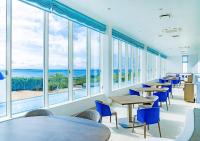 a cafeteria with tables and chairs and large windows at SANTORINI HOTEL&VILLAS MIYAKOJIMA in Miyako Island