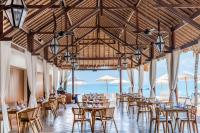 a restaurant with tables and chairs and the ocean at Lembongan Beach Club & Resort in Nusa Lembongan