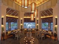 攀瓦海滩Amatara Welleisure Resort的一家有桌椅和大窗户的餐厅