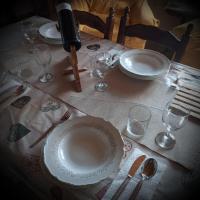 a table with plates and wine glasses on a table at Villa Malini in Grožnjan