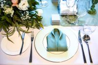 una mesa con un plato blanco con una servilleta verde en 深圳英威斯顿酒店 Investon Hotel Shenzhen, en Lung Wa